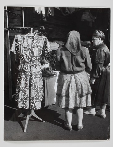 Két nő egy ruhát és cipőt árusító stand előtt. Magyarország, 1948. Fényképezte Robert Capa. Magyar Nemzeti Múzeum gyűjteménye, Budapest 