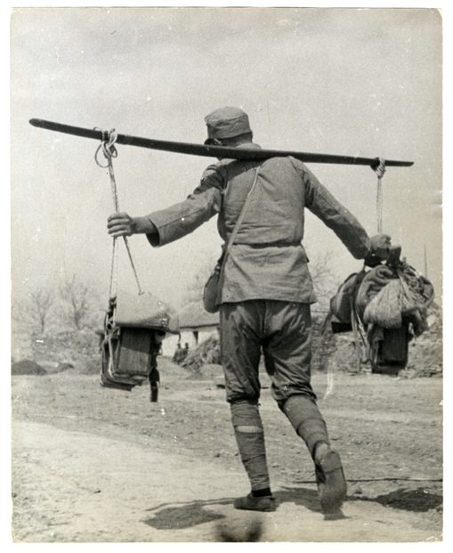 Kínai katona csomagokat tartó rudat egyensúlyoz egy koszos úton. Tai’erzhuang, Xuzhou front, Kína, 1938. április. Fényképezte Robert Capa. Magyar Nemzeti Múzeum gyűjteménye, Budapest 