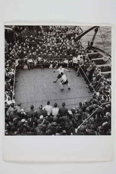 Brit katonák útközben boksz meccset néznek egy Észak-Afrikába tartó hajón. 1943. Fényképezte Robert Capa. Magyar Nemzeti Múzeum gyűjteménye, Budapest 